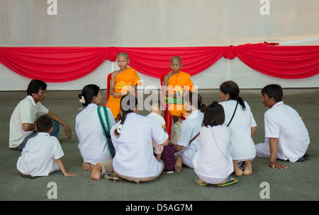 Junge buddhistische Mönche mit Gläubigen Stockfoto