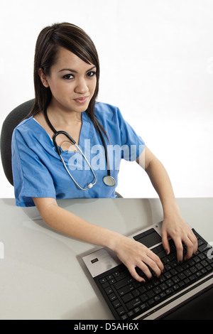 Ziemlich attraktive asiatische philippinischen Krankenschwester auf laptop Stockfoto