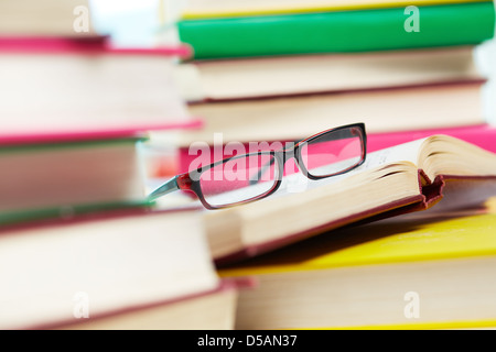 Nahaufnahme Bild von Brillen unter Haufen Bücher Stockfoto