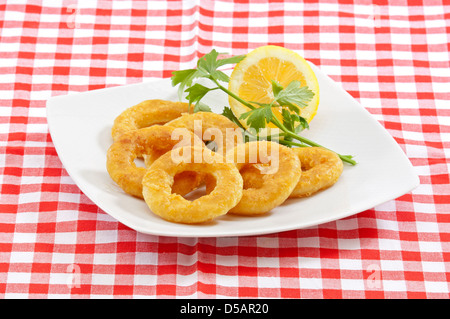 tiefe gebratene panierte calamari(squid) Ringe in einem weißen Teller auf einer traditionellen Serviette serviert Stockfoto