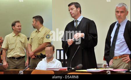 Angeklagten Sebastian L. sitzt auf der Anklagebank am Landgericht zwischen seinen Strafverteidiger Jochen Ringler (2-R) und Roland Autenrieth (R) und Justizbeamten vor Beginn der Prüfung in München, 13. Juli 2010. Zehn Monate nach dem Mord an dem Manager Dominik Brunner hat der Prozess gegen zwei junge Männer begonnen. Sebastian, 17 Jahre zum Zeitpunkt der Straftat, und Markus, 18 ye Stockfoto