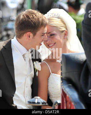 Spieler des FC Bayern Muenchen und Kapitän der deutschen Fußball-Nationalmannschaft Philipp Lahm (26) küsst seine Frau Claudia nach der kirchlichen Hochzeit in der Kirche von Kleinhelfendorf (Oberbayern), Deutschland, 14. Juli 2010. Nur waren Familienmitglieder und enge Freunde zur Hochzeit eingeladen. Foto: Peter Kneffel Stockfoto