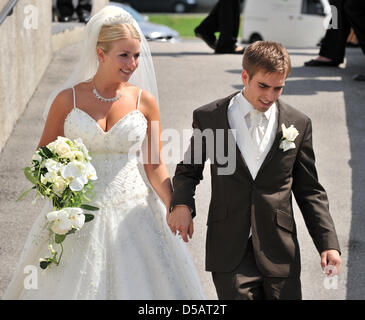 Spieler des FC Bayern Muenchen und Kapitän der deutschen Fußball-Nationalmannschaft Philipp Lahm und seine Frau Claudia verlassen die Kirche in Kleinhelfendorf (Oberbayern) nach der kirchlichen Hochzeit, Deutschland, 14. Juli 2010. Nur waren Familienmitglieder und enge Freunde zur Hochzeit eingeladen. Foto: Peter Kneffel Stockfoto