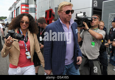 Deutsche Tennis-Legende Boris Becker (R) und seine Frau Lily Spaziergang durch das Fahrerlager im Jahr 2010 Formel 1 Grand Prix von Deutschland am Hockenheimring Rennstrecke in Hockenheim, Deutschland, 25. Juli 2010. Spaniens Alonso von Scuderia Ferrari gewann vor brasilianischer Teamkollege Massa und Deutschlands Vettel von Red Bull Racing. Foto: Ronald Wittek Stockfoto