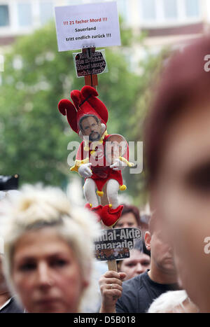 Ein Demonstrant hält eine Puppe auf einem Stock vor dem Rathaus in Duisburg, 29. Juli 2010. 200 Menschen forderte Bürgermeister Sauerland Rücktritt und die Opfer in einer Schweigeminute gedacht. Am 24. Juli 2010 21 Menschen starben und Hunderte von Menschen wurden verletzt, während eine Massenpanik bei Techno-Musik-Festival Loveparade. Foto: Oliver Berg Stockfoto