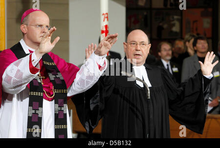 Der amtierende Vorsitzende der evangelischen Kirche in Deutschland (EKD), Nikolaus Schneider (R) und Bischof von Essen Franz-Josef Overbeck sermonise während der Trauerfeier für die Opfer der Loveparade-Massenpanik in der Salvator Kirche Duisburg, Deutschland, 31. Juli 2010. Die Opfer Verwandten und eidgenössischen Vertreter sind für die zentralen ökumenischen Gottesdienst am Salvator eingeladen. Stockfoto