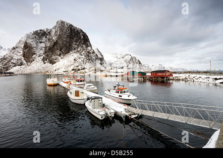 Ein Blick auf Boote gefesselt im hübschen Hafen von Hamnoy, mit Lilandstinden im Hintergrund Stockfoto