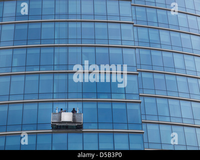 Fensterputzer arbeitet an einem Glas verkleidet Bürogebäude in Brüssel, Belgien Stockfoto