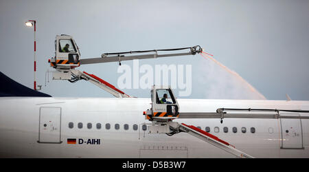 Zwei Männer versuchen, ein Flugzeug auf dem Flughafen in Frankfurt Main, Deutschland, 3. Januar 2010 betrieben. Starker Schneefall führte zu vielen Verzögerungen am Flughafen, 32 Flüge könnten überhaupt nicht in den Morgen starten. Foto: Fredrik von Erichsen Stockfoto