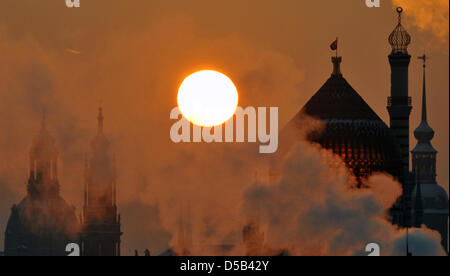 Bei frostigen Temperaturen geben Dämpfe von Heizungsanlagen die Szenerie kurz nach Sonnenaufgang vor der Altstadt mit den Kirchen "Frauenkirche" und "Hofkirche" und die Yenidzw (L-R) in Dresden, Deutschland, 5. Januar 2010. Prognosen zufolge wird es kälter in Sachsen die nächsten Tage sein. Foto: Ralf Hirschberger Stockfoto