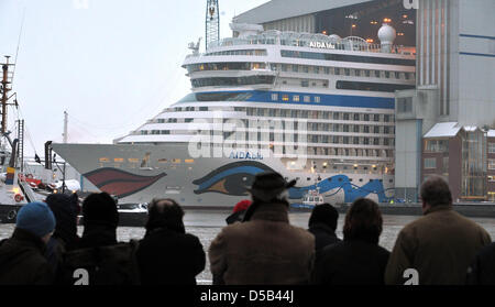 Neugierige Zuschauer beobachten, wie die 252 m lange neu entwickelte Kreuzfahrtschiff "AIDAblu" vor die Dock-Sperre von der Meyer-Werft, Papenberg, Deutschland, 5. Januar 2010 verschoben. Der her von sechs Schiffe geplant, denn die AIDA Schiffseigner Firma in Rostock, Deutschland auf der EMS in die Nordsee transportiert werden soll. Foto: Carmen Jaspersen Stockfoto