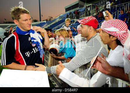 Deutsche Bundesliga-Verein FC Bayern Bastian Schweinsteiger (L) Autogramme während seines Vereins-Trainingslager in Dubai, Vereinigte Arabische Emirate, 7. Januar 2009. Foto: PETER KNEFFEL Stockfoto