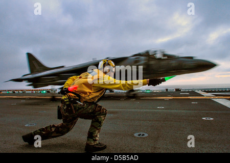 US Navy Flight Operations Seemann löscht ein Marinekorps AV-8 b Harrier II Jet Kampfflugzeug aus dem Flugdeck der amphibischen Angriff Schiff USS Boxer 26. März 2013 vor der Küste von Süd-Kalifornien auszuziehen. Stockfoto