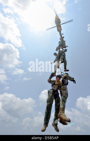 US Navy explosive Ordnance Entsorgung Techniker hängen an einem Seil Spion unter einem MH-60 s Sea Hawk während des Trainings 25. März 2013 über den Flugzeugträger USS John C. Stennis. Stockfoto