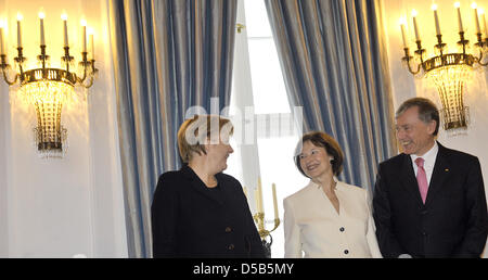 German Federal President Horst Koehler (R) und Frau Eva Luise (C) begrüßen deutschen Bundes Kanzlerin Angela Merkel (L) an den Anfang des neuen Jahres im Schloss Bellevue in Berlin, Deutschland, 12. Januar 2010. Unter mehr als 300 Gäste beim Neujahrsempfang des Bundespräsidenten waren Botschafter des gemeinsamen Lebens und ca. 60 Bürger aus allen Bundesländern, die engagiert Stockfoto