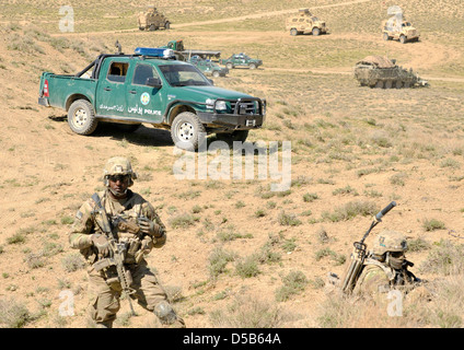 US-Armeesoldaten bieten Sicherheit als afghanische Grenzpolizei Pause Boden auf einen neuen Kontrollpunkt 25. März 2013 in den Bezirk von Spin Boldak, Provinz Kandahar, Afghanistan. Stockfoto