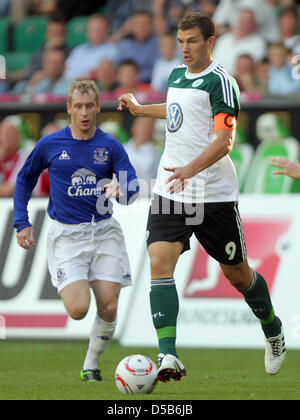 Wolfsburgs Edin Dzeko (R) bekommt den Ball vor Everton Tony Hibbert in einem Testspiel in Wolfsburg, Deutschland, 7. August 2010. Wolfsburg gewann das Spiel 2: 0. Foto: Jens Wolf Stockfoto