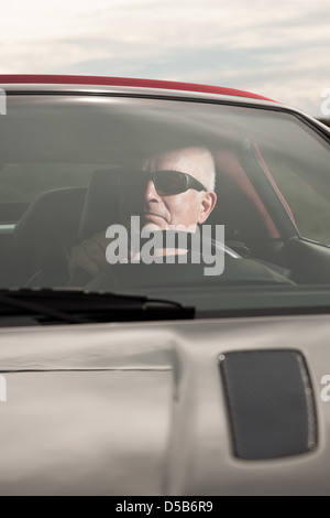 Pensionierter Mann in seinem Sportwagen. Stockfoto