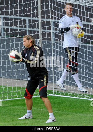 Torwart Tim Wiese (L) hält einen Ball, während Teamkollege Manuel Neuer (R) ihn während des Trainings der deutschen Fußball-Nationalmannschaft im Park Stadion in Kopenhagen, 10. August 2010 sieht. Am Mittwoch (11. August 2010) spielt Deutschland ein Freundschaftsspiel gegen Dänemark. Foto: Fabian Bimmer/dpa Stockfoto