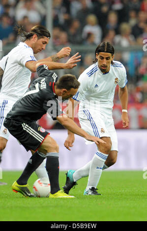 Bayern Franck Ribery (R) wird in einem Kampf um den Ball mit Real Madrid Spieler Sergio Ramos (L) und Sami Khedira während der Fußball-freundliche zwischen deutschen Fußballclub FC Bayern München und spanische Fußballverein Real Madrid im Fußballstadion Allianz Arena in München, 13. August 2010 gesperrt. Foto: Andreas Gebert Stockfoto