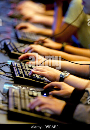 Besucher schauen Sie sich das Spiel "World of Warcraft" auf der Gamescom Messe in Köln, Deutschland, 18. August 2010. Europas größte Messe für interaktive Spiele findet vom 18. bis 22 August. Foto: Oliver Berg Stockfoto