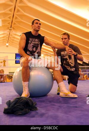 Ukrainischen Weltmeister im Boxen, Wladimir Klitschko (L), Stetches mit Hilfe von seinem Physiotherapeut Matthias Braunger in der Tennishalle des Hotel Stranglwirt in einem Trainingslager in Going, Österreich, 24. August 2010. IBF, IBO und WBO-Weltmeister Klitschko gegen den ehemaligen WBC-WM konkurrieren Weltmeister Peter am 11. September 2010. Foto: Tobias Hase Stockfoto