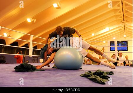 Ukrainischen Weltmeister im Boxen, Wladimir Klitschko (L), Stetches mit Hilfe von seinem Physiotherapeut Matthias Braunger in der Tennishalle des Hotel Stranglwirt in einem Trainingslager in Going, Österreich, 24. August 2010. IBF, IBO und WBO-Weltmeister Klitschko gegen den ehemaligen WBC-WM konkurrieren Weltmeister Peter am 11. September 2010. Foto: Tobias Hase Stockfoto