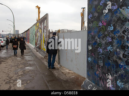 Touristen sehen Sie eine Lücke in der ehemaligen Berliner Mauer an der East Side Gallery in Berlin, Deutschland, 28. März 2013. Vier Elemente der Mauer wurden entfernt, um Platz für einen Zugang zu einer Baustelle zu machen. Ein Investor plant ein Hochhaus-Wohnung auf dem Grundstück direkt an der Spree. Foto: SOEREN STACHE Stockfoto