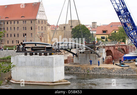 Ein Schwerlastkran hebt die erste Hälfte der zukünftigen Poeppelmann Brücke auf Pfeilern an der Mulde in Grimma, Deutschland, 8. September 2010. Die so genannte Sprengwerk mit 140tons Gewicht ist der erste Teil von die 65m lange Konstruktion aus Stahl gefertigt. Die fast 300 Jahre alte Brücke über die Mulde wurde im Jahr 2002 während der hundertjährigen Hochwasser beschädigt. Foto: Jan Woitas Stockfoto