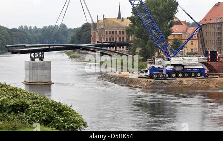 Ein Schwerlastkran hebt die erste Hälfte der zukünftigen Poeppelmann Brücke auf Pfeilern an der Mulde in Grimma, Deutschland, 8. September 2010. Die so genannte Sprengwerk mit 140tons Gewicht ist der erste Teil von die 65m lange Konstruktion aus Stahl gefertigt. Die fast 300 Jahre alte Brücke über die Mulde wurde im Jahr 2002 während der hundertjährigen Hochwasser beschädigt. Foto: Jan Woitas Stockfoto