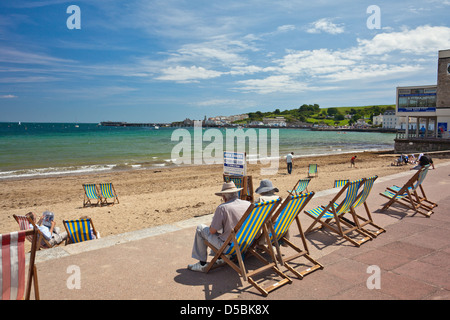 Liegestühle am Strand und der Promenade in Swanage in Dorset England UK Stockfoto