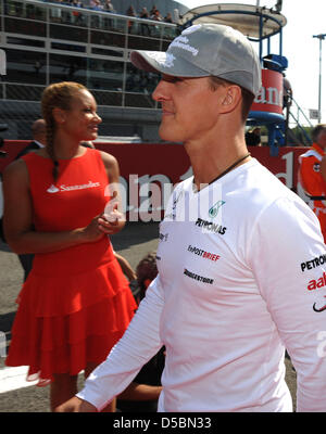 Deutsche Formel geht ein pilot Michael Schumacher (R) of Team Mercedes GP vorbei ein Raster-Mädchen vor dem Start des italienischen Grand Prix auf der Rennstrecke Autodromo Nazionale in Monza, Italien, 12. September 2010. Foto: Peter Steffen Stockfoto