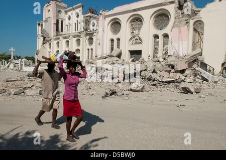 Ein Bild vom 15. Januar 2010 zeigt Paul Wendy, 8 Jahre alt und verletzten Dienstages Erdbeben, die von Vater Fritz Paul vorbei an den Trümmern Haitis National Cathedral, in Port au Prince, Haiti und seine Mutter Lamesa Jean durchgeführt werden. Haitianische Ärzte bitte um Hilfe inmitten der Katastrophe. WILLIAM B PLOWMAN/DPA (USA OUT/KEIN VERKAUF)) Stockfoto