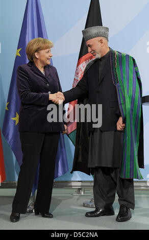 Bundeskanzlerin Angela Merkel und der afghanische Präsident Hamid Karzai die Hand nach einer Pressekonferenz auf die anstehende Afghanistan-Konferenz in London im Kanzleramt in Berlin, Deutschland, 27. Januar 2010. Die Bundesregierung plant, bis 2014, den Rückzug der deutschen Soldaten aus Afghanistan mit einer neuen Strategie vorzubereiten, während die Zahl der Soldaten von 850 auf 5350 Stockfoto