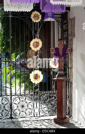 Oaxaca de Juárez, Mexiko. 27. März 2013.  Einfache Holzkreuz mit Trauer Farben & Rosetten am Eisernen Tor bedeutet Karwoche; Oaxaca de Juárez, Mexiko, 27. März 2013 Stockfoto