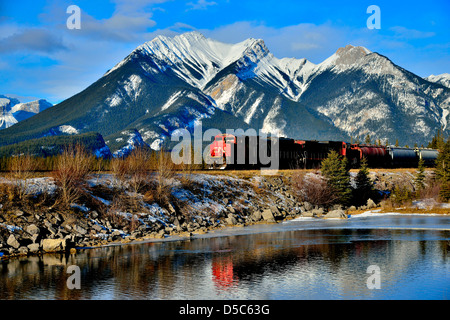 Ein Canadian National Güterzug vorbei an einem schneebedeckten rocky mountain Stockfoto