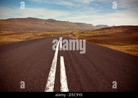 Autobahn durch trockenen Kies Lava Feld Landschaft unter einem blauen Sommerhimmel. Hochland von Central Island. Stockfoto