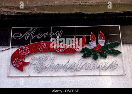 Frohe Weihnachts-Dekorationen hängen immer noch auf eine Dundee Einzelhandel speichern Wand Ende März 2013, UK Stockfoto