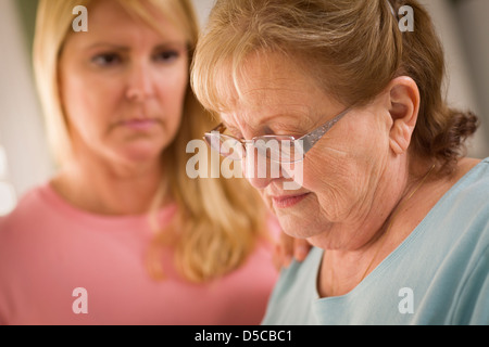 Junge Frau tröstet traurige Senior Erwachsenfrau. Stockfoto