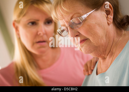 Junge Frau tröstet traurige Senior Erwachsenfrau. Stockfoto