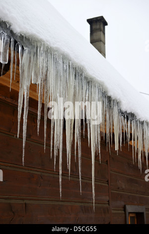 Eiszapfen und Schnee bedeckt Holzhäuser in dem malerischen Dorf Chocholow im Tatra-Gebirge in der Nähe von Zakopane Polen. Stockfoto