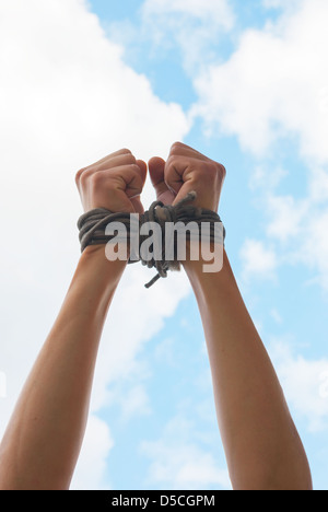 Händen gefesselt mit einem Seil gegen blauen Himmel Stockfoto