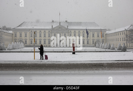 Berlin, Deutschland, steht Frau auf Schnee allein an einer Bushaltestelle vor dem Schloss Bellevue Stockfoto