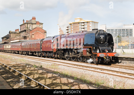 Eine Dampflok zieht einen Personenzug auf der Hauptstrecke bei Wakefield Kirkgate Station, West Yorkshire, England Stockfoto