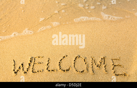 Herzlich Willkommen - geschrieben im Sand am Strand Textur (weiche Welle des Meeres) Stockfoto