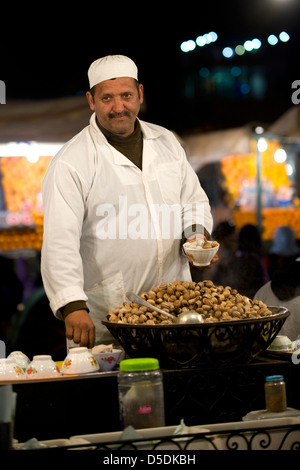 Ein Mann verkauft gekochte Schnecken auf einem Wochenmarkt Stand in Djemaa al Fna Platz in Marrkesh, Marokko Stockfoto
