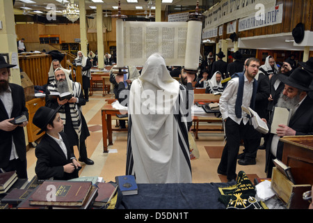 Tora-Rolle wird ausgelöst, nachdem eine Lesung am Wochentag Morgen Dienstleistungen Lubawitsch Hauptquartier in Brooklyn, New York. Stockfoto