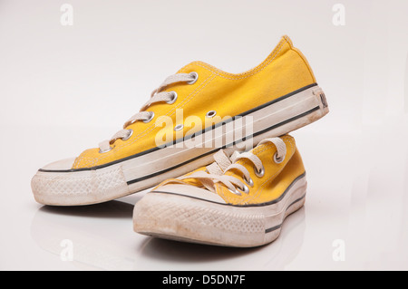 Gelbe farbige Turnschuhe mit weißen Schnürsenkeln Stockfoto