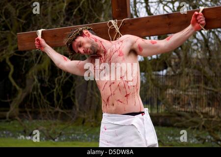 Cambridge, Cambridgeshire, Großbritannien. 29. März 2013. Ein Mann erschafft die Kreuzigung von Jesus Christus im Vorfeld bis zu Ostern auf der Königs-Parade im Schatten des Kings College, Cambridge, um der Öffentlichkeit die wahre Bedeutung von Ostern am Karfreitag zu erinnern. 29. März 2013. Stockfoto