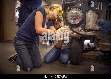 Das Tragen von Schutzbrille arbeiten zwei Mädchen im Teenageralter zusammen auf ein Auto im Auto-laden-Klasse in San Clemente, Kalifornien. Stockfoto